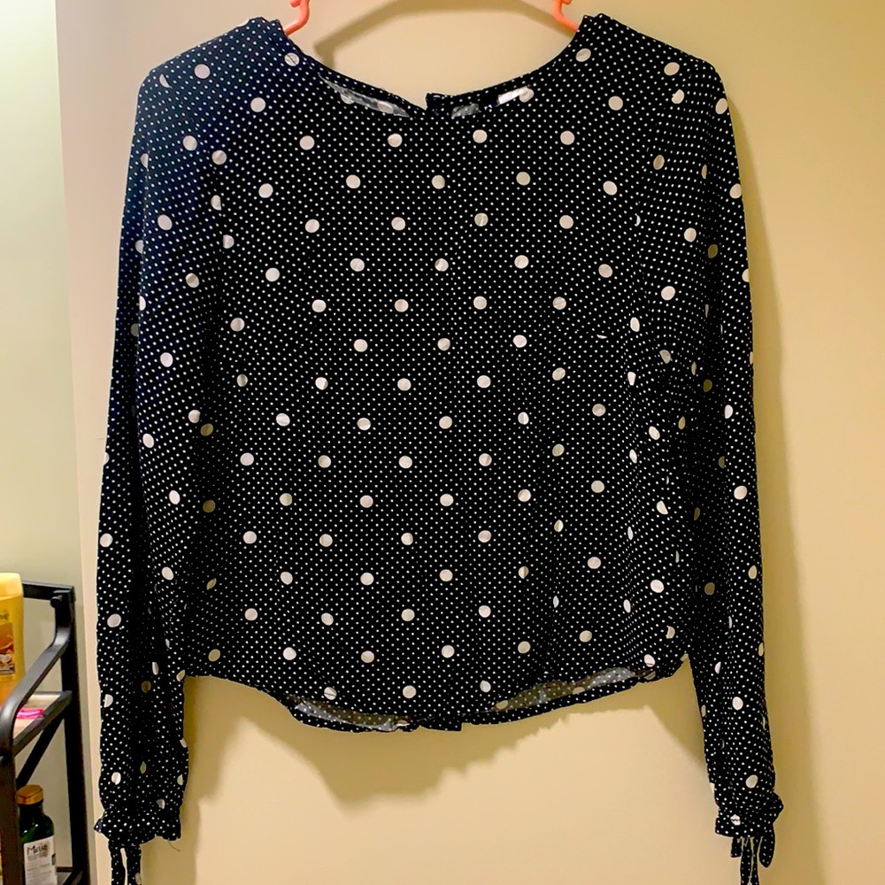 Long sleeve black and white polka dotted top with cuffed sleeves and cute bows